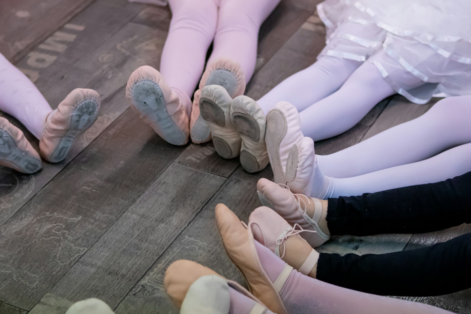 Young dancers sitting together on a studio floor during a class
